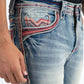 Close-up front of blue jeans with decorative stitching on a white background