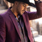 Man wearing a dark cowboy hat and burgundy blazer in an outdoor setting