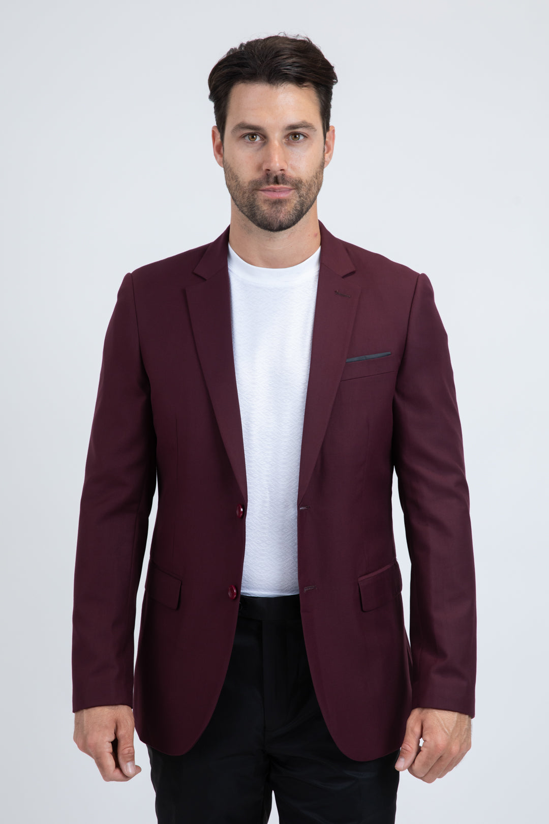 Man wearing a burgundy blazer over a white shirt on a white background