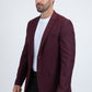 Man wearing a burgundy blazer over a white shirt on a white background