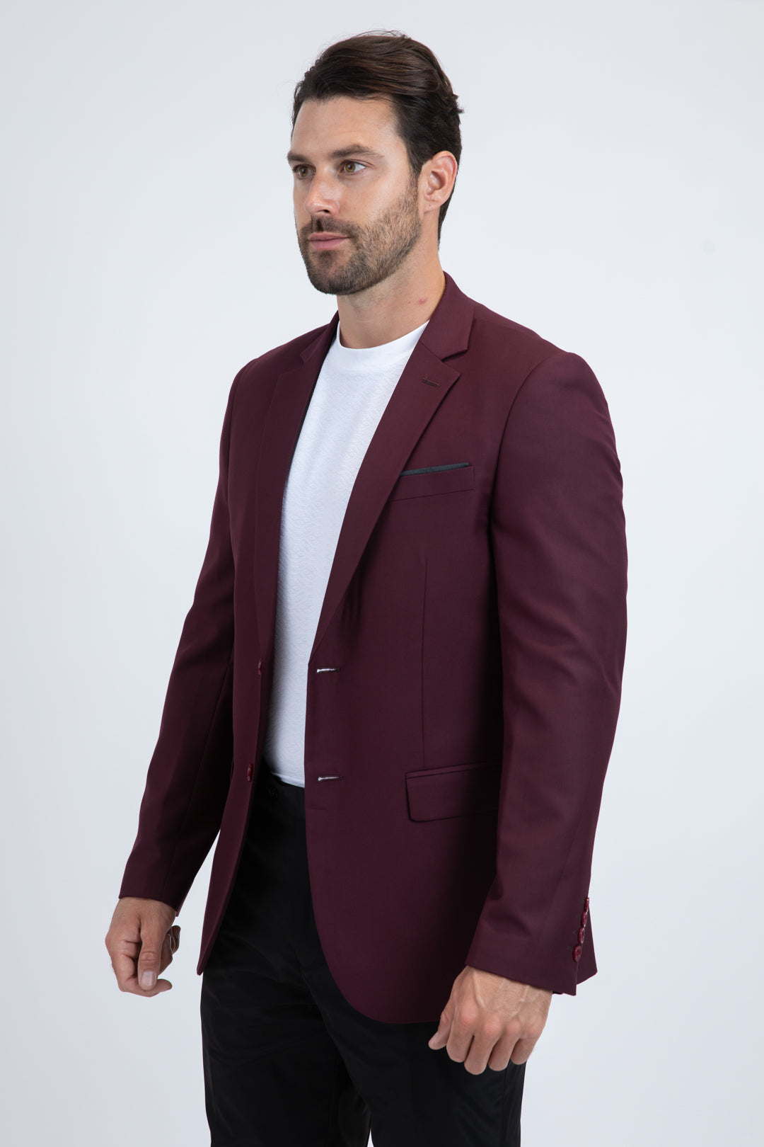 Man wearing a burgundy blazer over a white shirt on a white background