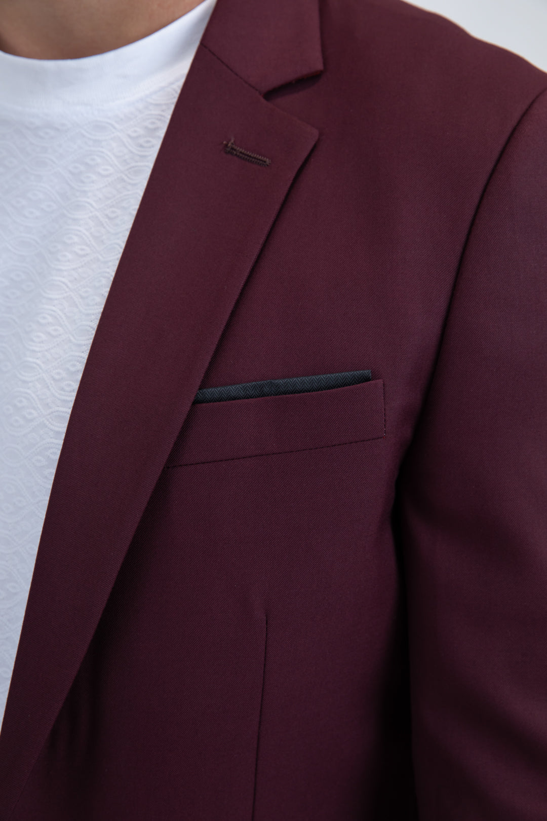 Close-up of a burgundy blazer with a white shirt underneath