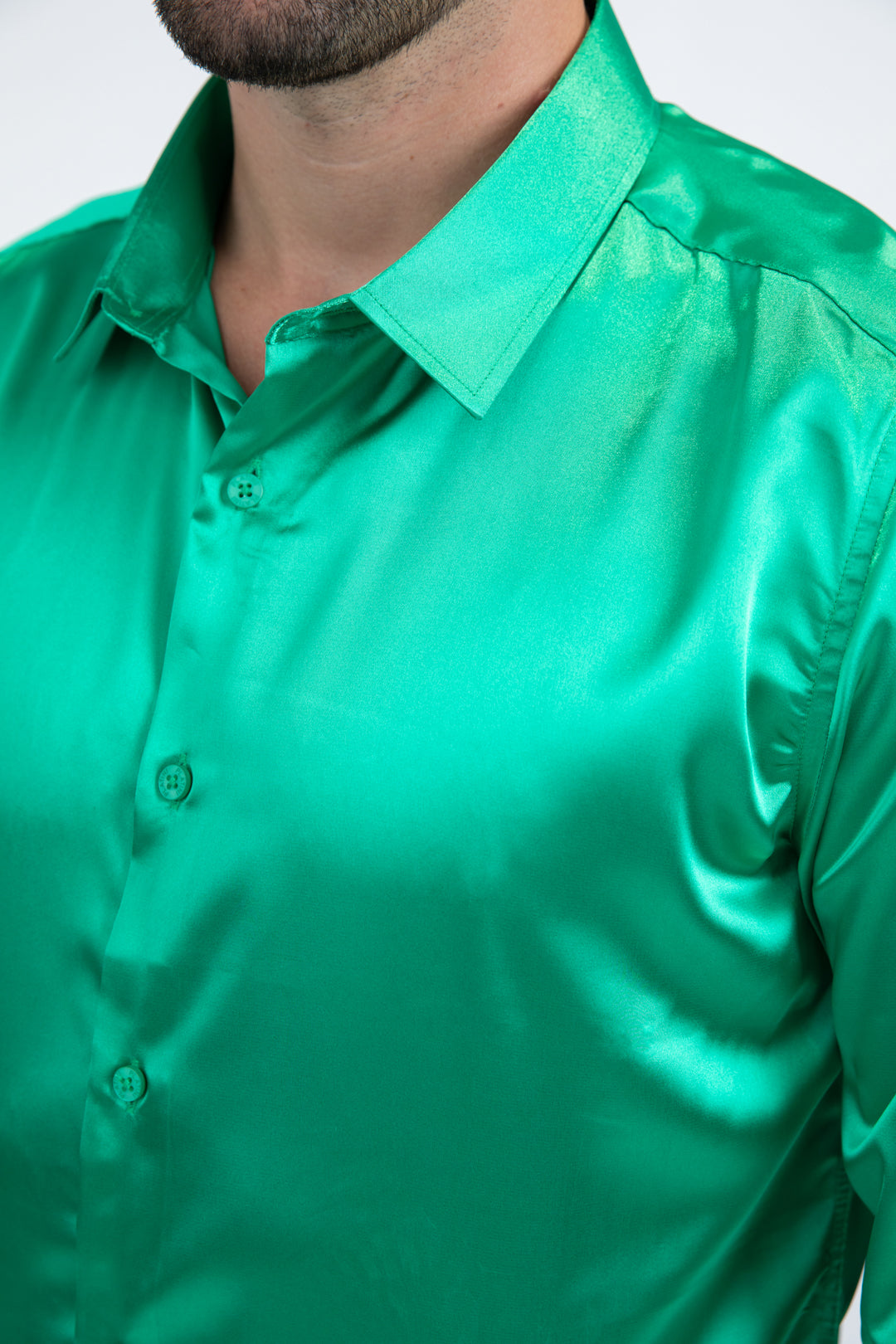 Green satin shirt worn by a person on a white background